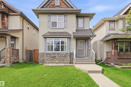 Two-story exterior with light-colored siding, a stone facade, and a gabled roof - 204 59 Street Sw, Edmonton, AB - Outdoor With Facade