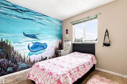 Bedroom featuring tile flooring, large windows with natural light, and a striking custom mural wall depicting an underwater seascape with marine life and aquatic flora - 204 59 Street Sw, Edmonton, AB - Indoor Photo Showing Bedroom