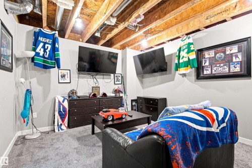 Recessed overhead lighting, exposed ceiling joists, grey carpeting, and light-toned wall paint - 204 59 Street Sw, Edmonton, AB - Indoor