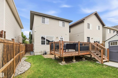 Spacious backyard oasis featuring a composite deck with black metal railings, manicured lawn, white river rock landscaping, and wooden privacy fencing - 204 59 Street Sw, Edmonton, AB - Outdoor With Deck Patio Veranda With Exterior