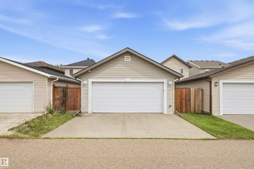 Detached garage with horizontal siding, a gable roof, and a panel garage door - 204 59 Street Sw, Edmonton, AB - Outdoor