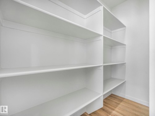 Built-in shelving system with white finishes, offering extensive storage capacity - 239 Kinglet Boulevard Nw, Edmonton, AB - Indoor With Storage
