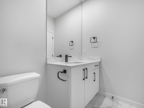 Bathroom vanity with a white countertop, undermount sink, and matte black faucet - 239 Kinglet Boulevard Nw, Edmonton, AB - Indoor Photo Showing Bathroom