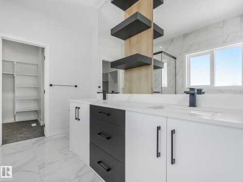 Dual vanity with integrated sinks, quartz countertops, and matte black fixtures - 239 Kinglet Boulevard Nw, Edmonton, AB - Indoor Photo Showing Bathroom