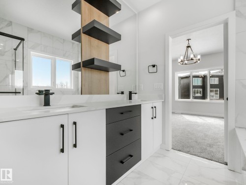 Contemporary bathroom vanity featuring dual sinks, white countertops, black matte fixtures, and built-in shelving - 239 Kinglet Boulevard Nw, Edmonton, AB - Indoor