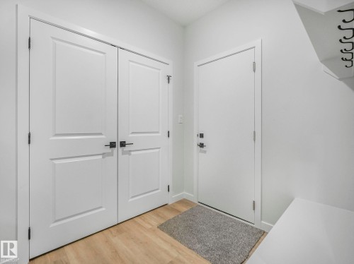 Entry area featuring wood-finish flooring and crisp white walls - 239 Kinglet Boulevard Nw, Edmonton, AB - Indoor Photo Showing Other Room
