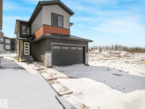 Modern two-story residence featuring a two-tone exterior with dark siding and light upper accents - 239 Kinglet Boulevard Nw, Edmonton, AB - Outdoor