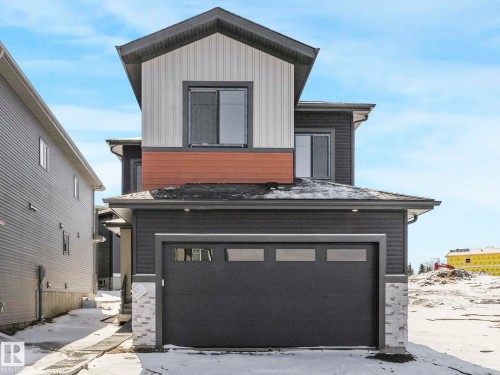 Contemporary exterior featuring dark gray siding, light vertical siding, and a contrasting wood-tone accent band - 239 Kinglet Boulevard Nw, Edmonton, AB - Outdoor