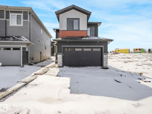 Contemporary two-story exterior featuring dark gray siding with white and terracotta accent panels - 239 Kinglet Boulevard Nw, Edmonton, AB - Outdoor