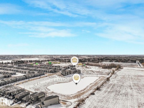 Aerial perspective showcasing a residential development with a frozen pond - 239 Kinglet Boulevard Nw, Edmonton, AB - Outdoor With View