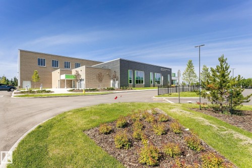 Modern commercial building with two-tone brick facade, multiple large windows, and a dedicated paved entrance - #310 2229 44 Av Nw, Edmonton, AB - Outdoor