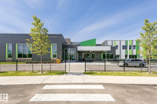 Modern institutional building featuring a gray brick facade, large windows, and contrasting green accent panels - #310 2229 44 Av Nw, Edmonton, AB - Outdoor