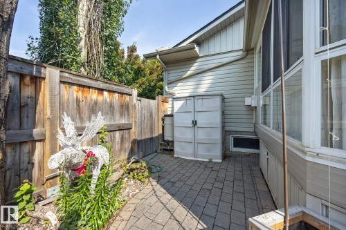 Paver stone patio with a wood privacy fence and a built-in storage shed - 9503 54 Street Nw, Edmonton, AB - Outdoor With Exterior