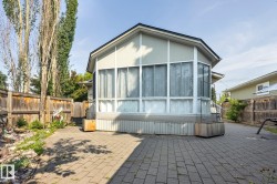 Modern residential structure featuring expansive multi-panel windows, peaked roofline with contemporary architectural detailing, and corrugated metal siding accents - 