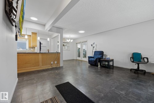 Open-concept living area with tiled flooring, recessed lighting, and light wood cabinetry - 9503 54 Street Nw, Edmonton, AB - Indoor