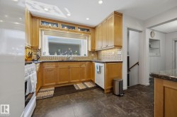 Kitchen featuring wood cabinetry, a large window, recessed lighting, tile flooring, and a built-in dishwasher - 
