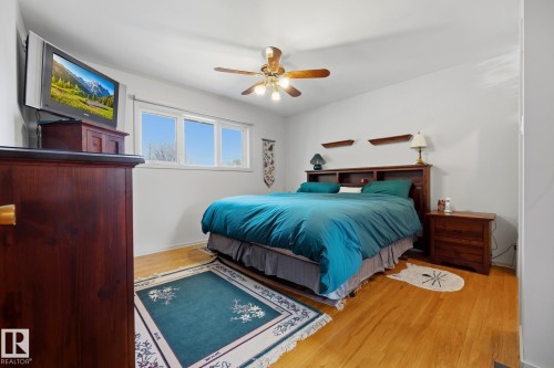 Wood-finish flooring, white walls, and a ceiling fan with light fixture - 9503 54 Street Nw, Edmonton, AB - Indoor Photo Showing Bedroom