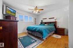 Wood-finish flooring, white walls, and a ceiling fan with light fixture - 