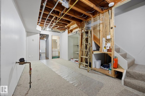 Unfinished basement with exposed wood-frame ceiling structure, concrete flooring, and multiple utility areas - 9503 54 Street Nw, Edmonton, AB - Indoor Photo Showing Basement