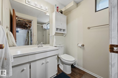 Bright bathroom featuring a white vanity with ample storage, ceramic sink, and large mirror with integrated lighting - 9503 54 Street Nw, Edmonton, AB - Indoor Photo Showing Bathroom
