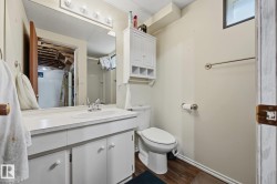 Bright bathroom featuring a white vanity with ample storage, ceramic sink, and large mirror with integrated lighting - 