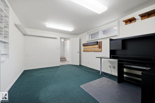 Versatile commercial or residential space featuring polished concrete flooring, recessed LED ceiling lighting, built-in cabinetry with storage shelving, and a black appliance unit - 9503 54 Street Nw, Edmonton, AB - Indoor Photo Showing Other Room