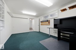 Versatile commercial or residential space featuring polished concrete flooring, recessed LED ceiling lighting, built-in cabinetry with storage shelving, and a black appliance unit - 