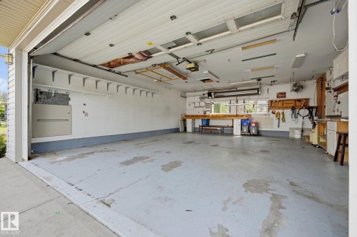 Spacious two-car garage with epoxy-coated concrete flooring, wall-mounted storage systems, built-in cabinetry, and overhead lighting throughout - 9503 54 Street Nw, Edmonton, AB - Indoor Photo Showing Garage