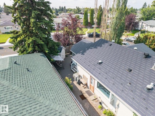 Aerial perspective showcasing two distinct roof systems featuring dimensional asphalt shingles in contrasting gray and sage tones, with multiple roof penetrations and professional installation - 9503 54 Street Nw, Edmonton, AB - Outdoor