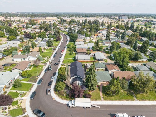 Aerial view showcasing a well-landscaped residential property featuring mature trees, manicured lawn, and a curved driveway with ample parking - 9503 54 Street Nw, Edmonton, AB - Outdoor With View