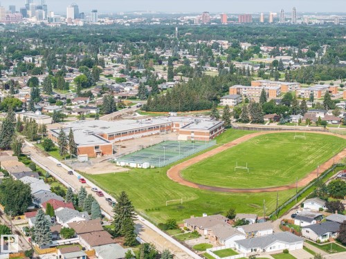 Athletic facility featuring a regulation-size track with infield soccer field, professional-grade synthetic playing surface, and adjacent indoor sports complex with orange brick construction - 9503 54 Street Nw, Edmonton, AB - Outdoor With View