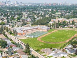 Athletic facility featuring a regulation-size track with infield soccer field, professional-grade synthetic playing surface, and adjacent indoor sports complex with orange brick construction - 