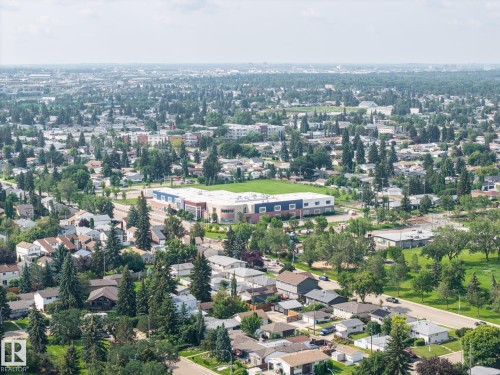 Additional content  The photo is an aerial view showing a large commercial or industrial building (purple/blue structure) surrounded by residential neighborhoods, mature trees, and developed areas - 9503 54 Street Nw, Edmonton, AB - Outdoor With View