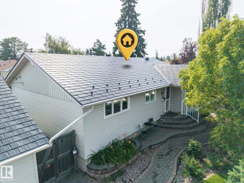 Contemporary home featuring a steeply pitched architectural roofline with dimensional asphalt shingles, light-colored horizontal siding, and multi-pane windows - 9503 54 Street Nw, Edmonton, AB - Outdoor