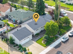 Charming single-story residence featuring a freshly resurfaced dark gray asphalt shingle roof, detached two-car garage with matching roofline, and mature landscaping including tall evergreen trees and manicured lawn - 