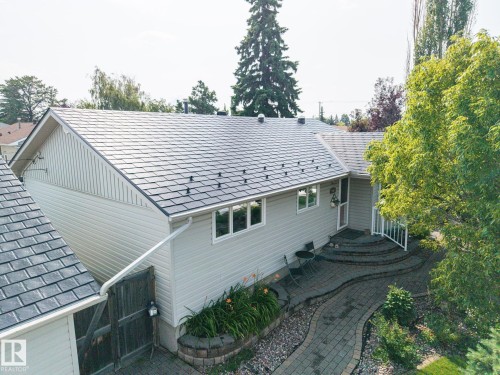 Contemporary home showcasing a freshly installed slate-colored asphalt shingle roof, white vertical siding exterior, and multi-pane windows - 9503 54 Street Nw, Edmonton, AB - Outdoor