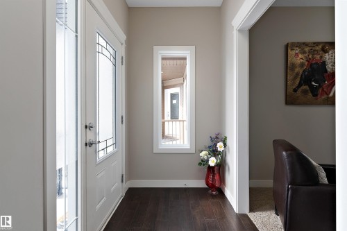 Entryway featuring dark wood-finish flooring, white trim, and a frosted glass-panel door - 1312 26 Avenue Nw, Edmonton, AB - Indoor Photo Showing Other Room