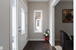 Entryway featuring dark wood-finish flooring, white trim, and a frosted glass-panel door - 
