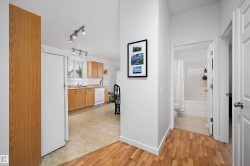 Kitchen with wood-finish flooring, light wood cabinetry, and white appliances - 