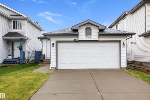 Two-story residence featuring white siding and a prominent two-car garage - 3344 24 Avenue Nw, Edmonton, AB - Outdoor With Exterior