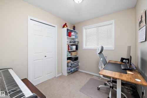 Neutral tone walls with white trim, carpeting, a white bi-fold closet, and a white framed window - 3344 24 Avenue Nw, Edmonton, AB - Indoor Photo Showing Office