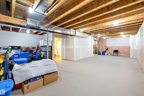 Spacious lower level offering exposed wood joists, overhead lighting, and extensive unfinished wall space for customization - 3344 24 Avenue Nw, Edmonton, AB - Indoor Photo Showing Basement