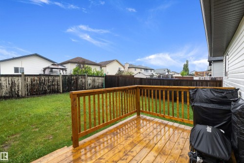 Wood-finish deck with railing overlooking a green lawn - 3344 24 Avenue Nw, Edmonton, AB - Outdoor With Deck Patio Veranda With Exterior