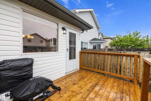 Wood-finish deck with a natural wood railing, white siding exterior, and exterior wall lantern - 3344 24 Avenue Nw, Edmonton, AB - Outdoor With Deck Patio Veranda With Exterior
