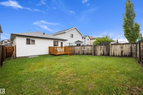 Expansive backyard featuring a lush lawn, a multi-level wood deck, and wood fencing - 3344 24 Avenue Nw, Edmonton, AB - Outdoor With Deck Patio Veranda