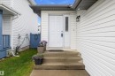 White paneled siding exterior featuring a white paneled entry door with an adjacent vertical window pane - 3344 24 Avenue Nw, Edmonton, AB  - Outdoor With Exterior 