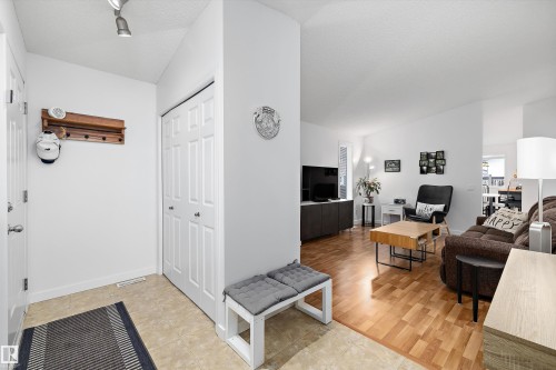 Entryway with track lighting, an adjacent closet, and tile flooring transitioning to wood-finish flooring in the main living area - 3344 24 Avenue Nw, Edmonton, AB - Indoor Photo Showing Living Room