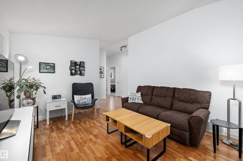 Bright living area featuring wood-finish flooring and white walls - 3344 24 Avenue Nw, Edmonton, AB - Indoor Photo Showing Living Room