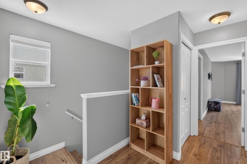 Light wood-finish flooring, built-in shelving, white trim, and neutral wall tones - #25 200 Erin Ridge Dr, St. Albert, AB - Indoor Photo Showing Other Room