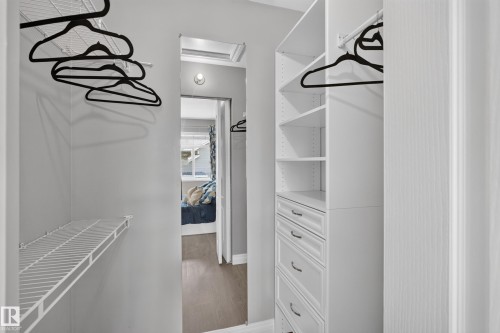 Walk-in closet featuring white cabinetry with multiple drawers, wire shelving, black hanging rods, and recessed lighting throughout the space - #25 200 Erin Ridge Dr, St. Albert, AB - Indoor Photo Showing Other Room
